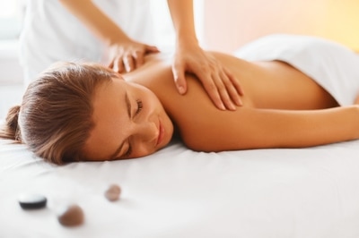 A woman laying on her stomach getting a massage.