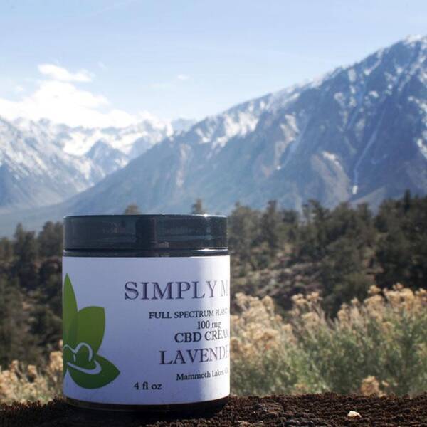 A jar of lavender tea sitting in front of the mountains.
